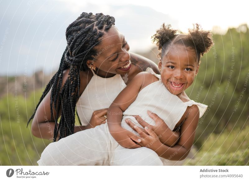 Afroamerikanische Mutter spielt mit Tochter in der Natur Landschaft spielen Kribbeln Sommer Wochenende Glück Zusammensein spielerisch Frau Mädchen schwarz