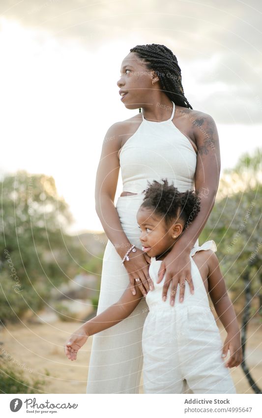 Schwarze Mutter und Tochter bewundern die Landschaft Zusammensein Sonnenuntergang Sommer Liebe berühren Wochenende Frau Mädchen wolkig Kind Eltern schwarz