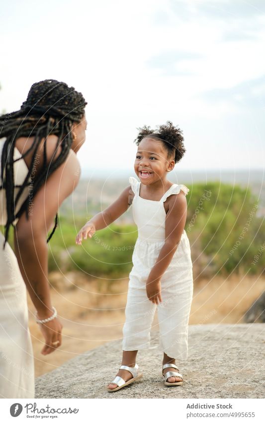 Afroamerikanische Tochter spricht mit ihrer Mutter sprechen Landschaft Zusammensein Lächeln Glück Gespräch Stein Liebe Frau Mädchen schwarz Afroamerikaner