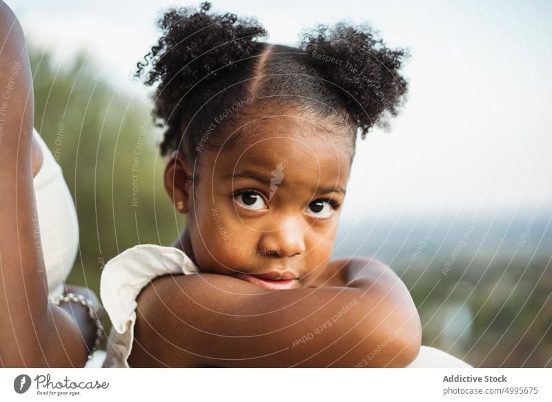 Afroamerikanisches Mädchen schaut in die Kamera in der Nähe der Mutter Tochter Landschaft Sommer Wochenende Zusammensein Generation Porträt niedlich Kind Eltern