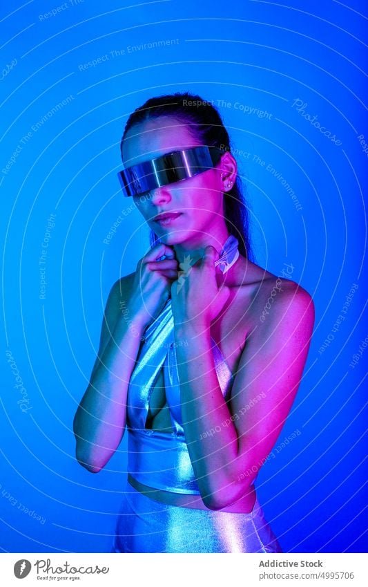 Selbstsichere futuristische Frau erkundet den Cyberspace in einer VR-Brille Virtuelle Realität Erfahrung Stil selbstbewusst zuschauen digital neonfarbig