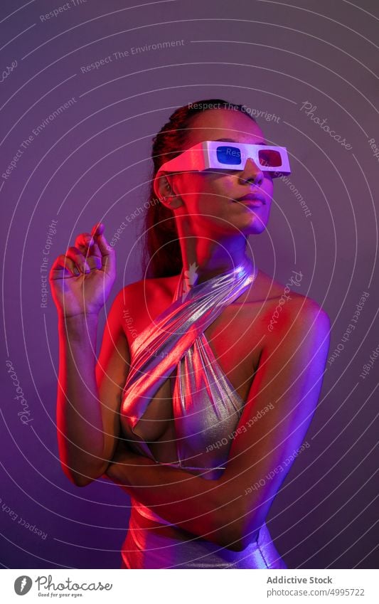 Aufmerksame verführerische junge Dame, die virtuelle Realität in einem lila Studio erlebt Frau selbstbewusst Virtuelle Realität futuristisch Stil VR Innovation