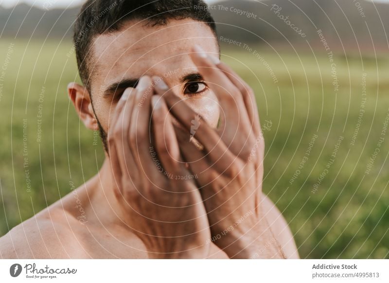 Ruhiger hispanischer Mann, der sein Gesicht in der Natur bedeckt Deckblatt ohne Hemd Feld ernst Tierhaut Windstille Persönlichkeit ruhig selbstbewusst friedlich