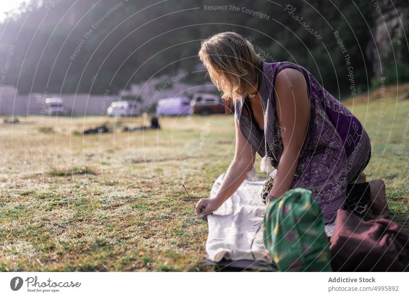 Anonyme Frau legt Räucherstäbchen auf fettigen Rasen vor der Meditation Weihrauch kleben Harmonie Wiese meditieren Erholung Aromatherapie Sprit Schamane Ritual
