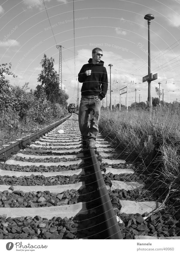 railway-walker Eisenbahn Mann maskulin Gleise Außenaufnahme Sonnenbrille schwarz weiß Wiese Körperhaltung Pullover Bahnhof Coolness Himmel Jeanshose