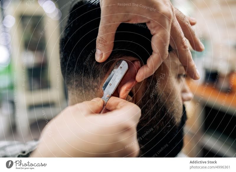 Friseur, der die Haare eines Kunden mit einem Rasiermesser schneidet Rasierer gerade Klinge Haarschnitt Klient geschnitten Pflege Barbershop Männer stechend