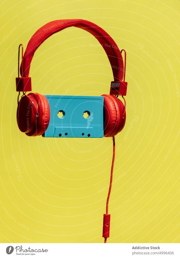 Retro-Kassette im Kopfhörer auf gelbem Hintergrund Audio zuhören Musik retro Klebeband altehrwürdig farbenfroh Nostalgie Album hell klassisch stereo Klang