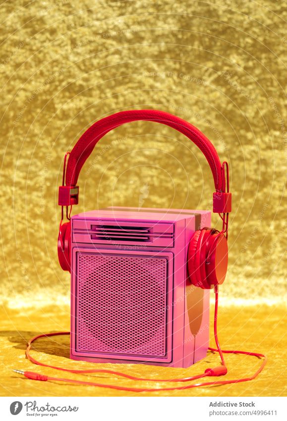 Kopfhörer auf Retro-Musiklautsprecher im Studio Redner retro stereo zuhören Konzept Nostalgie Klang Headset Draht Audio altehrwürdig farbenfroh Album hell