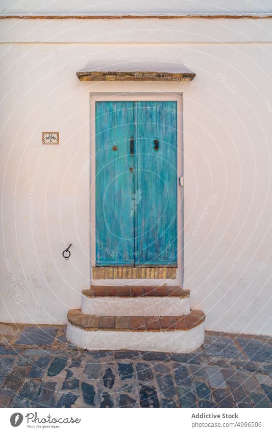 Blaue Holztür in verputzter alter Wand Tür Außenseite schäbig Eingang Fassade gealtert Farbe Stein Haus Gebäude verwittert Türöffnung türkis Eingabe Stadt