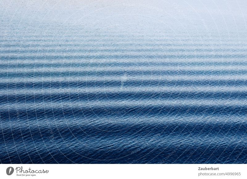 Regelmäßige Wellen verlaufen horizontal auf blauem Meer als Muster regelmäßig friedlich Weite Wasser weit Bewegung auslaufen