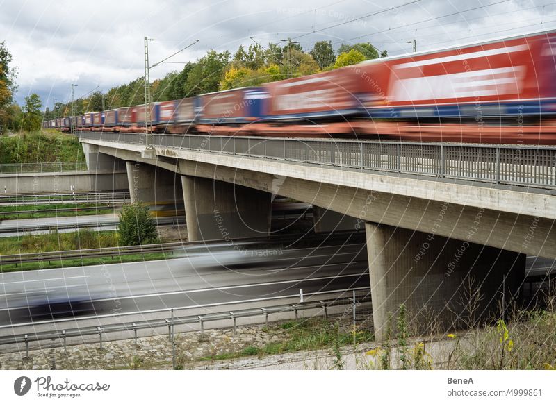 Eisenbahn, die eine Autobahn kreuzt Herbst Brücke Gebäude PKW Ladung Träger Arbeitsweg Beton fahren Umwelt Europa fallen Fernstraße Fracht Güterzug