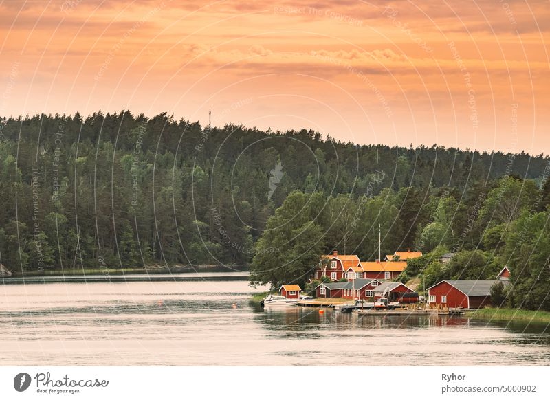 Schweden. Viele schöne rote schwedische Holzblockhäuser Häuser auf Rocky Island Coast. See oder Flusslandschaft Schwedisch Appartement Inselgruppe Badehaus