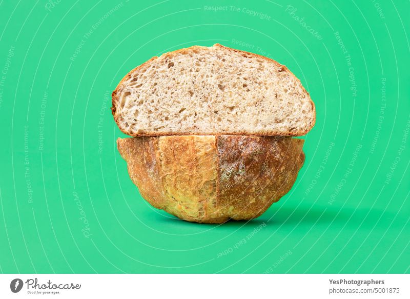 Aufgeschnittenes Brot auf grünem Hintergrund. Weißbrot mit Sesamsamen. Kunstgewerbler gebacken Bäckerei hell braun Kohlenhydrate Nahaufnahme Farbe Kruste Küche