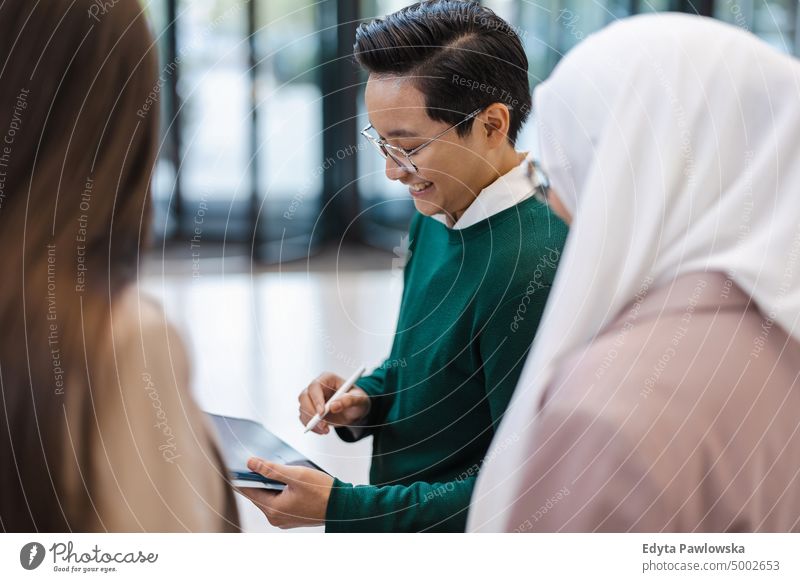 Junger Geschäftsmann zeigt seinen Kollegen etwas auf einem Tablet im Büro multirassische Gruppe Team Vielfalt Teamwork muslimisch multiethnisch Business