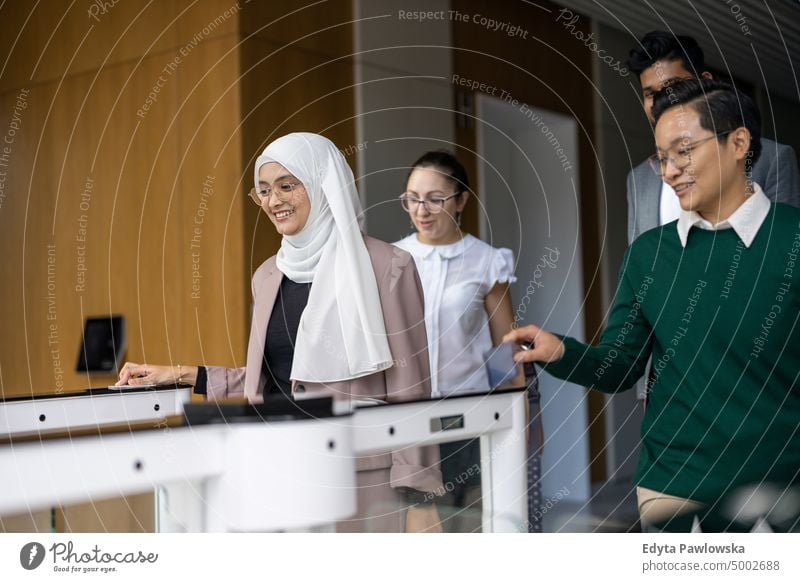 Junge Geschäftsleute, die ihren Arbeitsplatz durch Sicherheitsdrehkreuze betreten multirassische Gruppe Team Vielfalt Teamwork muslimisch multiethnisch Business