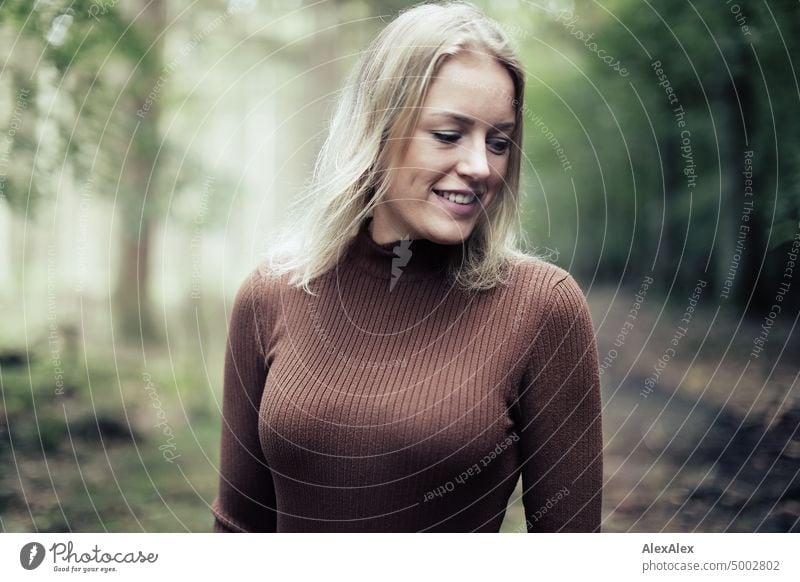 Junge, blonde Frau mit Grübchen steht im Wald und lächelt glücklich in die Kamera junge Frau feminin schön Jugendliche Portrait Erwachsene natürlich authentisch