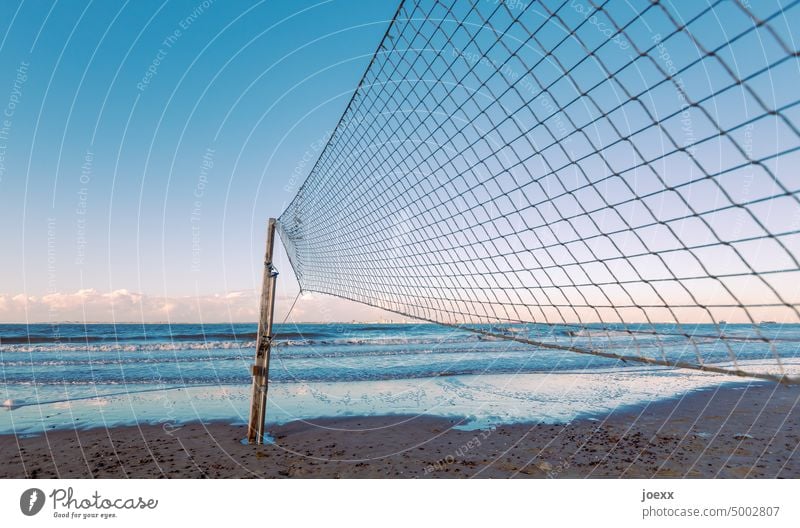 Beach-Volleyballnetz direkt am Strand mit Meer bei Abendstimmung Schönes Wetter Wellen Wind Himmel Wolken Unendlichkeit Menschenleer Außenaufnahme blau braun