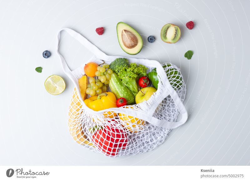 Frisches Obst und Gemüse in Shopper auf grauem Hintergrund. Gesunde Ernährung und Null-Abfall-Konzept. Flachlage. Frühstück Essen zubereiten kulinarisch Entzug