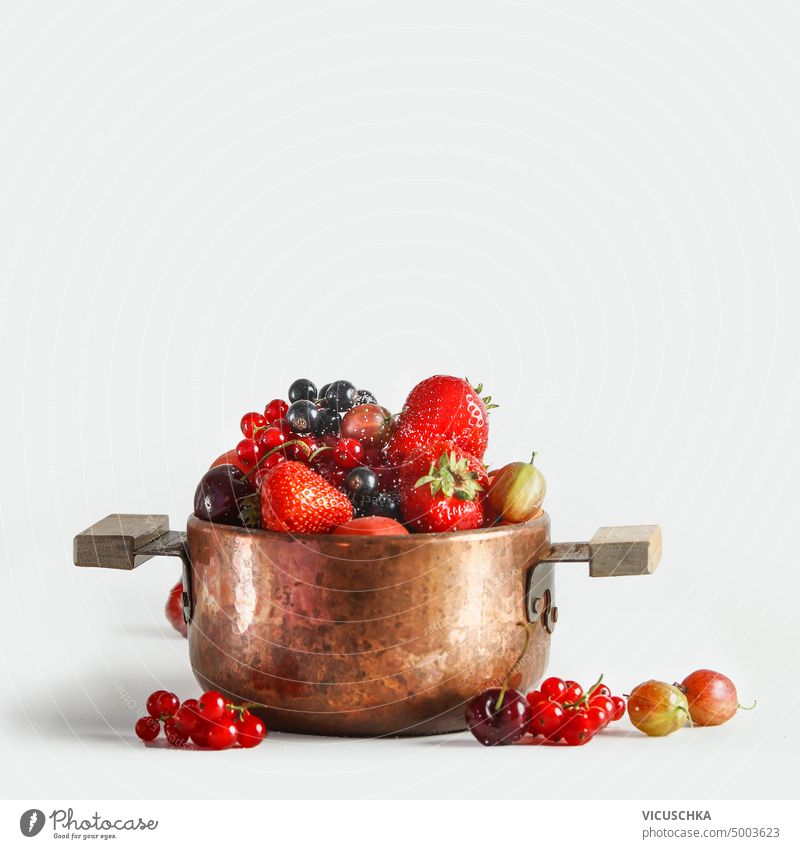 Kupfer Kochtopf mit frischen Früchten und Beeren st weißem Hintergrund Kupferkessel weißer Hintergrund Vitamine Saison Marmelade Konfiture bewahren Objekt