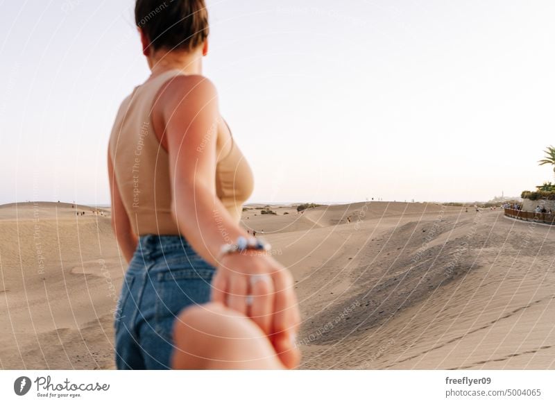 Touristin hält die Hand ihres Partners in der Wüste von Maspalomas Paar Liebe Flitterwochen Düne laufen wüst Sand Gran Canaria Textfreiraum Kanarische Inseln