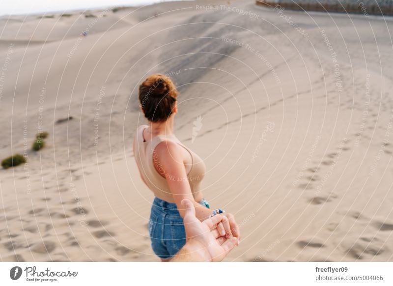 Touristin hält die Hand ihres Partners in der Wüste von Maspalomas Paar Liebe Flitterwochen Düne laufen wüst Sand Gran Canaria Textfreiraum Kanarische Inseln