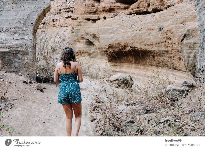 Frau geht durch eine ausgetrocknete Schlucht laufen Tourist Natur Besuch reisen wandern blau Textfreiraum Kleid Fluss desertierend trocknen vulkanisch Steine
