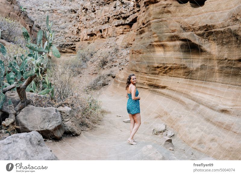Frau geht durch eine ausgetrocknete Schlucht laufen Tourist Natur Besuch reisen wandern blau Textfreiraum Kleid Fluss desertierend trocknen vulkanisch Steine