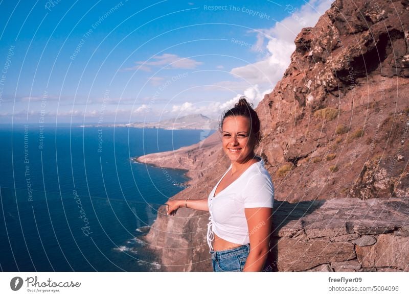 Frau mit Blick auf das Meer von einem Aussichtspunkt aus Porträt jung Natur Textfreiraum blau Tourist wandern reisen Gran Canaria Kanarische Inseln Spanien