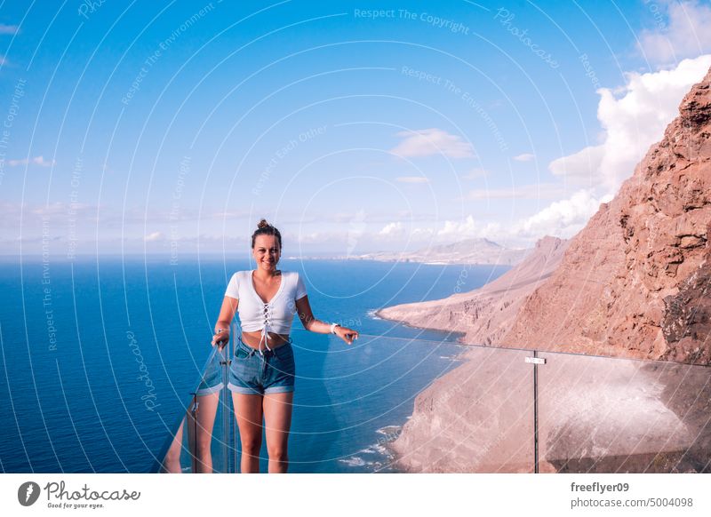 Tourist auf einem Aussichtspunkt mit Blick auf das Meer und die vulkanischen Klippen jung Frau Natur Textfreiraum blau wandern reisen Gran Canaria