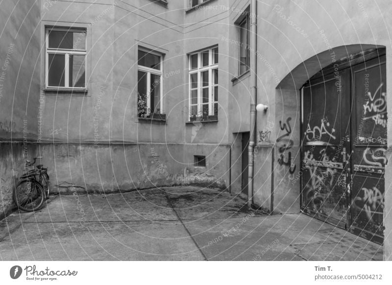 Hinterhof mit Rad in Prenzlauer Berg Berlin s/w Fenster Innenhof Hof Stadtzentrum Altbau Haus Tag Menschenleer Altstadt Hauptstadt Schwarzweißfoto Gebäude