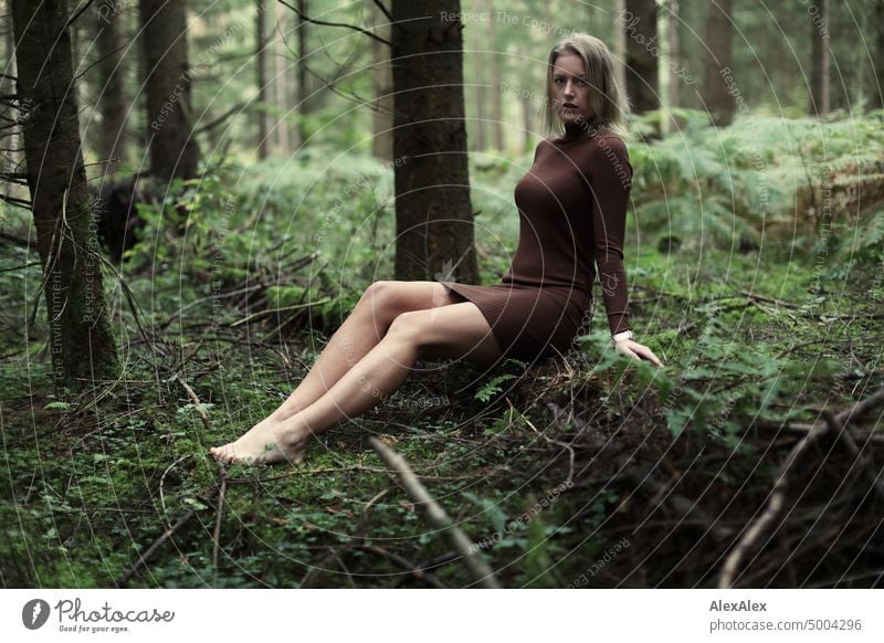 Junge, blonde Frau sitzt barfuß auf einem umgefallenen Baumstamm im Wald junge Frau feminin schön glücklich Jugendliche Portrait Erwachsene natürlich