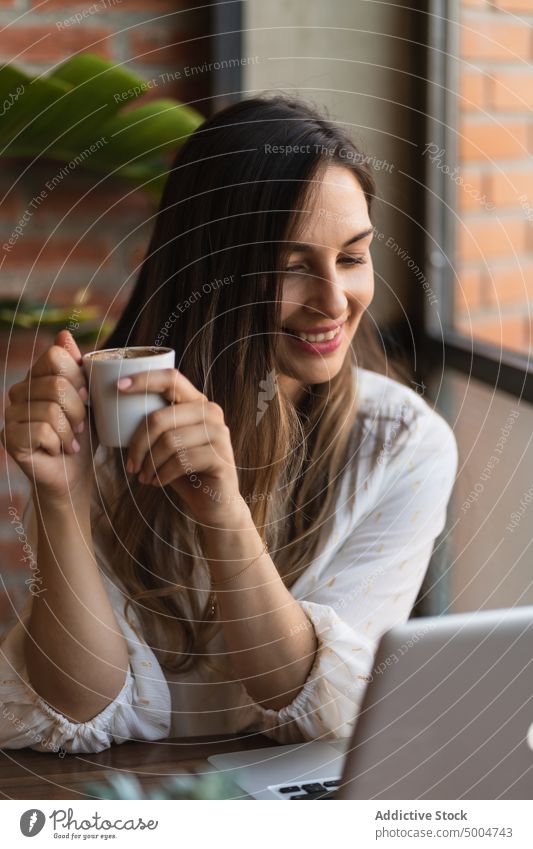 Freiberuflerin trinkt Kaffee in einem Cafe Frau freiberuflich schlürfen Café Kaffeepause Laptop Telearbeit Tasse Heißgetränk jung unabhängig Apparatur Gerät