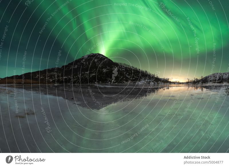 Aurora borealis am Nachthimmel über verschneiten Bergen Nordlicht Berge u. Gebirge nördlich polar Licht Himmel See Winter leuchten Norwegen Lofoten Inseln Natur