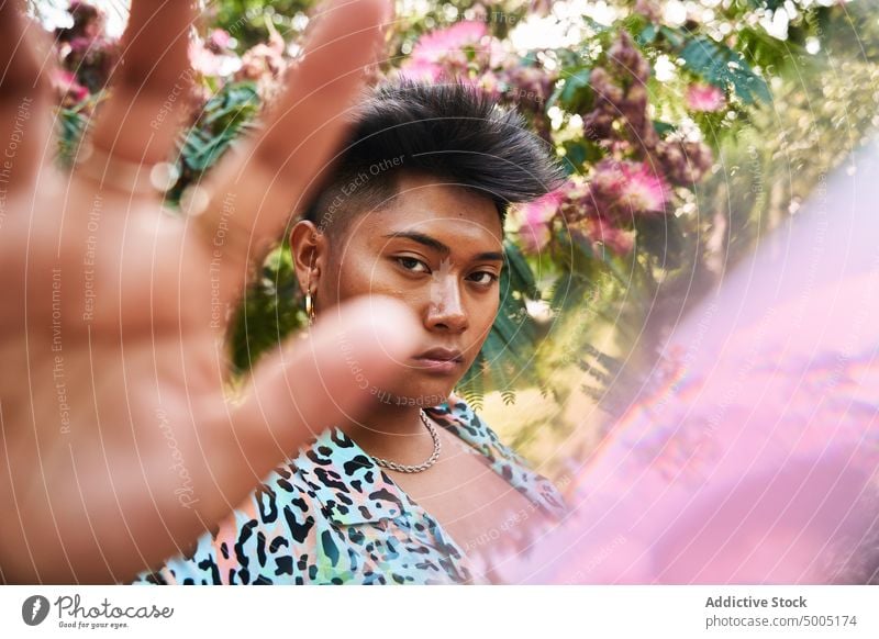 Filipinische Transgender-Frau gestikuliert Stopp stoppen gestikulieren Garten Baum Blütezeit lgbt nicht binär verbieten Blume ethnisch asiatisch Filipinos