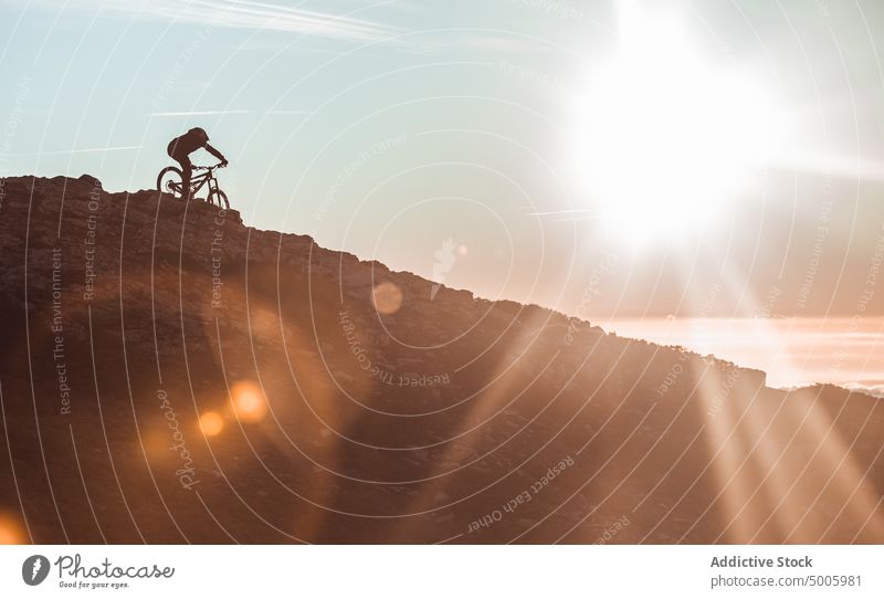 Mann fährt mit dem Fahrrad auf einem Hügel Reiten Schutzhelm extrem Sport Berge u. Gebirge Top Typ Himmel Sonne Sonnenschein männlich Sicherheit