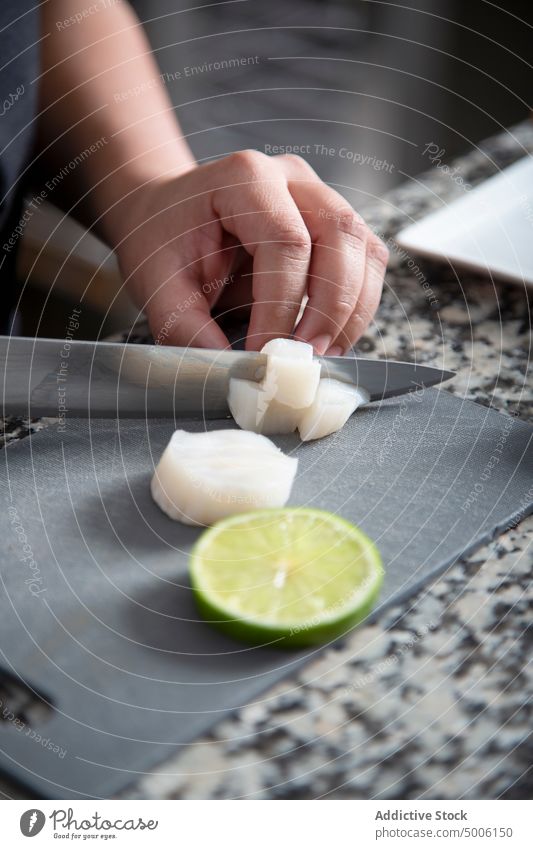 Unbekannter Koch schneidet weißen Daikon Küchenchef Kalk Gemüse geschnitten kulinarisch Restaurant Zitrusfrüchte professionell vorbereiten Würfel Gastronomie