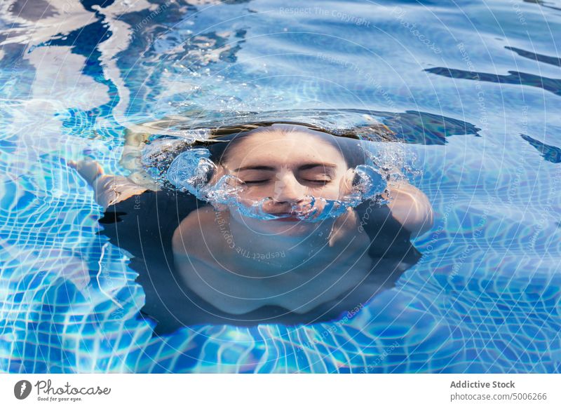 Frau schwimmt in blauem Pool schwimmen unter Wasser Erfrischung Schaumblase Sommer auftauchen Feiertag genießen jung Urlaub Resort Aktivität Erholung Sommerzeit