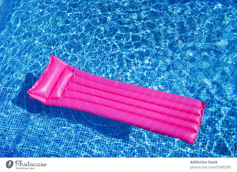 Aufblasbare Matratze im Freibad Beckenrand Pool aufblasbar Sommer Schlafmatratze Wasser rosa farbenfroh Sonnenlicht Schwimmer durchsichtig übersichtlich blau