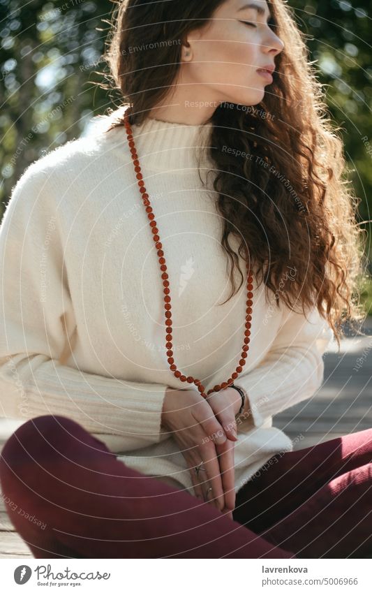 Brünette Frau im weißen Pullover meditiert in einem Park, selektiver Fokus Mala-Perlen Erwachsener allein attraktiv Herbst brünett lässig Kaukasier krause Haare