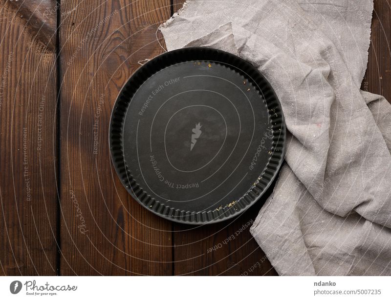 Leere schwarze runde Antihaft-Kuchenform auf einem braunen Holztisch Tisch Ofen Pfanne Gebäck Pasteten Stahl Werkzeug Top traditionell Tablett Utensil hölzern