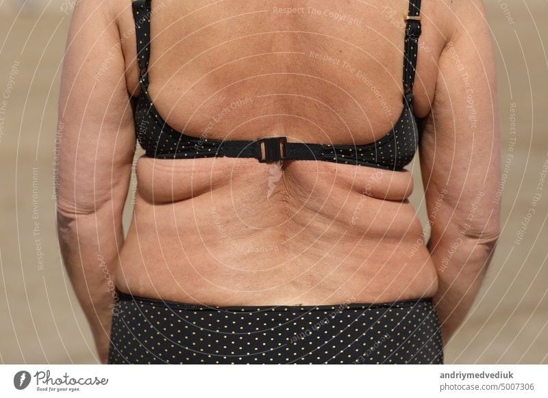 dicke Frau mit Übergewicht, Rückenansicht, schlaffe Seiten und Rücken mit Fettfalten, übergewichtiger fetter Körper als Folge falscher Ernährung. Hohe Qualität Foto