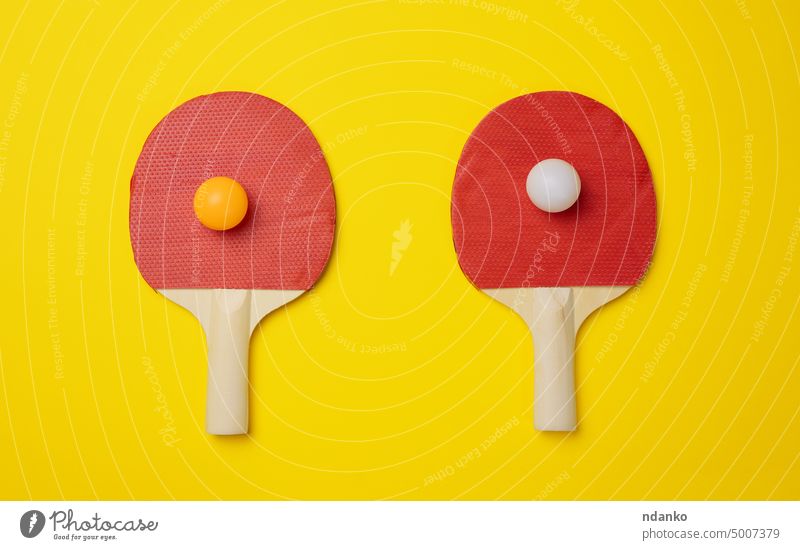 Ein Paar hölzerne Tennisschläger für Tischtennis auf einem gelben Hintergrund Ball Sport Spiel Remmidemmi Gerät Freizeit pong wettbewerbsfähig Paddel Ping