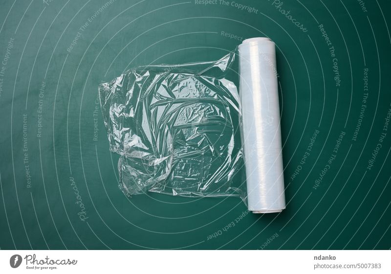 Rolle mit transparenter Lebensmittelfolie für Lebensmittelverpackungen auf grünem Hintergrund Filmmaterial flach Verpackung Kunststoff Polyethylen Polyäthylen