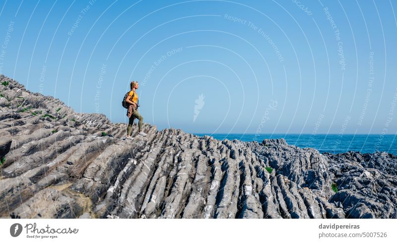 Frau mit Rucksack geht durch Flyschfelsenlandschaft Textfreiraum junger Erwachsener laufen Trekking wandern Landschaft Meereslandschaft Felsen MEER Menschen