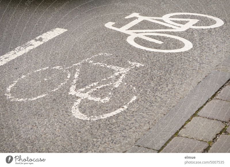 altes und neues Piktogramm eines Fahrrades, im 90 Grad Winkel zueinander stehend, kennzeichnen einen Radfahrstreifen auf der Straße Fahrradweg Radfahrweg Radweg