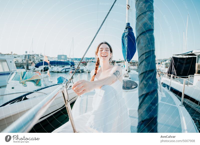 Junge glückliche Frau fühlt sich Spaß auf dem Luxus-Segelboot während ihrer Sommerferien. Ruhige junge Frau sitzt auf Segelboot. Getting das Boot bereit zu segeln. Urlaub, Jugend und Spaß Konzept