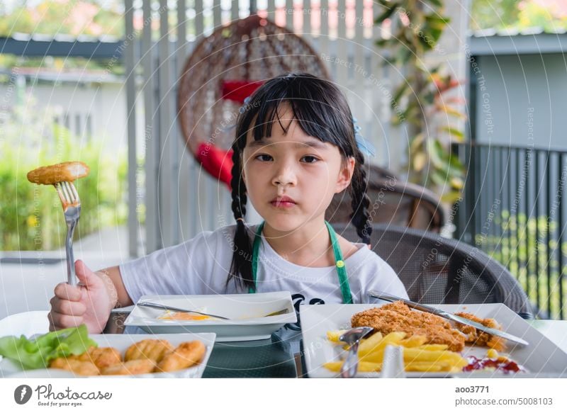 Asiatisches junges Mädchen Essen Chicken Nuggets Fast Food auf dem Tisch. Hähnchen Person Kind Fotografie eine Person Frau Farbbild Fastfood Porträt
