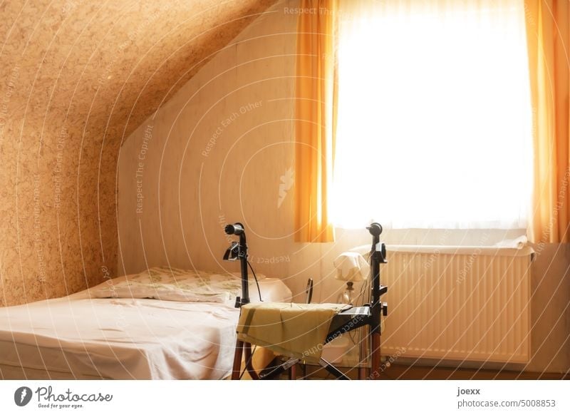 Rollator in einem spärlich eingerichteten Schlafzimmer an einem Bett Gehhilfe Mobilität Einsamkeit Schlaftimmer Gesundheitswesen Farbfoto Innenaufnahme Fenster