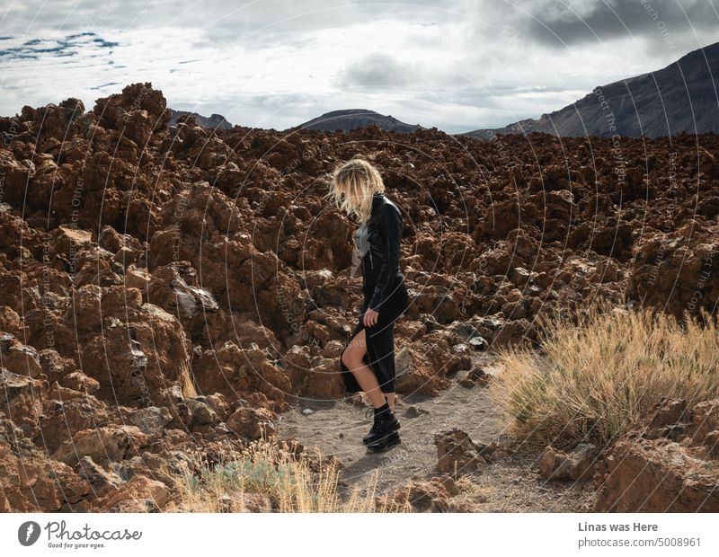 Die natürliche Schönheit des Teide auf Teneriffa. Und es ist nicht nur ein Vulkan und eine unwegsame Umgebung. Ein wunderschönes blondes Mädchen in schwarzer Lederkleidung läuft herum. Ein echter Rockstar in einer felsigen Landschaft.