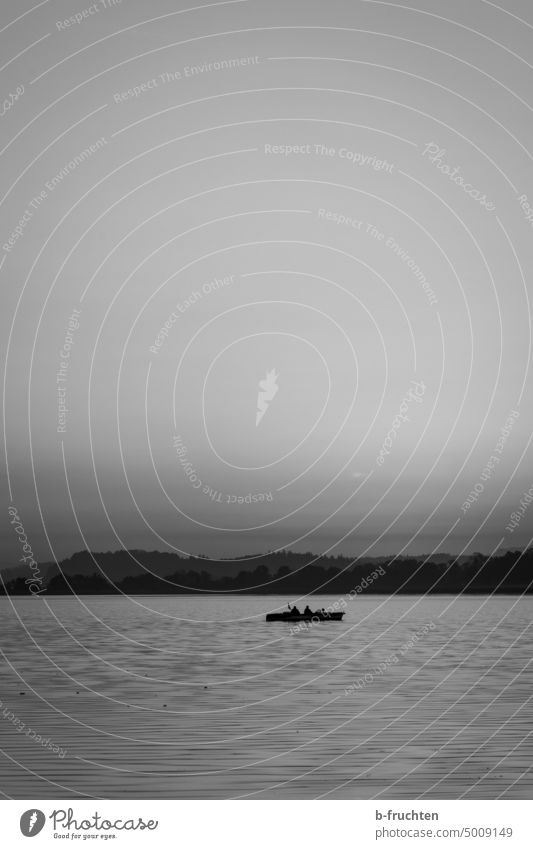 Elektroboot alleine auf dem See Bootsfahrt Seeufer Außenaufnahme Wasser ruhig Erholung Himmel Landschaft Idylle Natur Wasseroberfläche Motorboot Schwarzweißfoto
